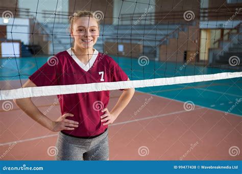 Smiling Female Volleyball Player Standing With Hand On Hips In The