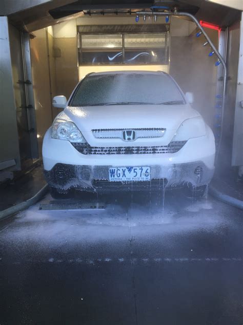 A man washing his car at a do it yourself car wash. Torquay Carwash: Wash Your Car in Torquay! Open 24H