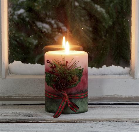 Christmas Candle Glowing On Window Sill With Snowy Evergreen Bra