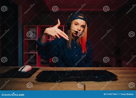 Serious Female Gamer In Headset Plays Video Games At Night On Computer