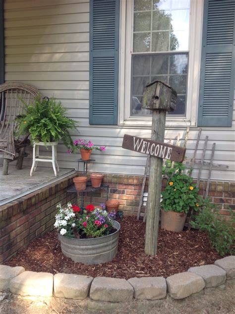 A Welcome Sign Sitting On Top Of A Wooden Pole In Front Of A House With