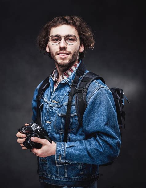 Portrait Of A Handsome Young Photographer With Curly Hair Wearing Denim