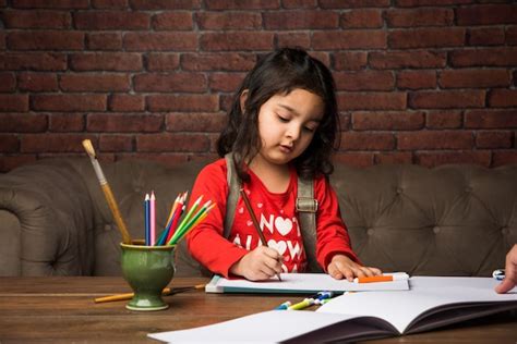 Premium Photo Indian Small Girl Drawing Or Painting With Colours Over