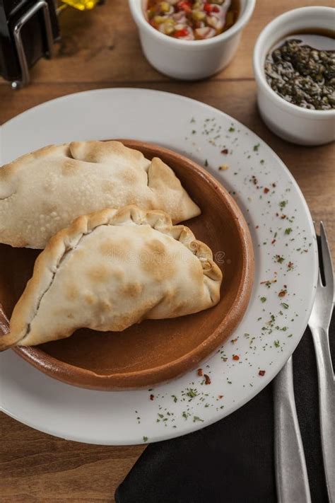 Delicious Argentine Empanadas On A Wooden Board On A White Background