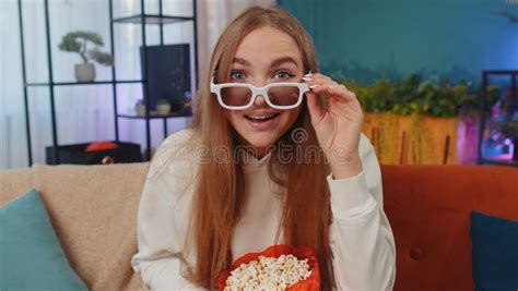 Woman Sitting On Couch Eating Popcorn And Watching Interesting Tv