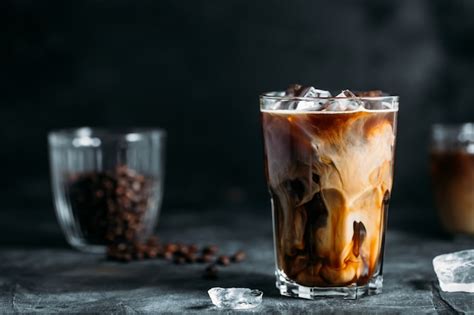 Premium Photo Milk Being Poured Into Iced Coffee On A Dark Table