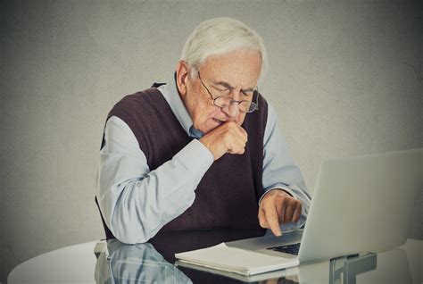 Elderly old man using laptop computer sitting at table - SOLUTIONS FOR ...