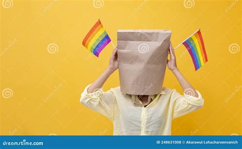 Portrait Of Shy Lgbtq People Covering Her Face Waving Rainbow Flag For Coming Out Of The Closet