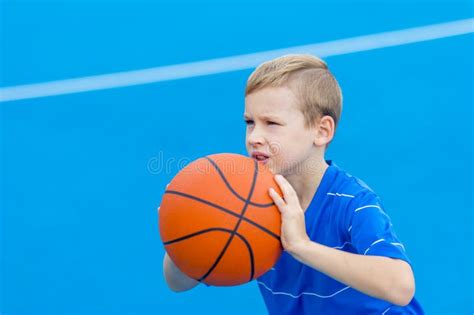 Adorable Child Playing The Basketball In The Basket Field Stock Photo