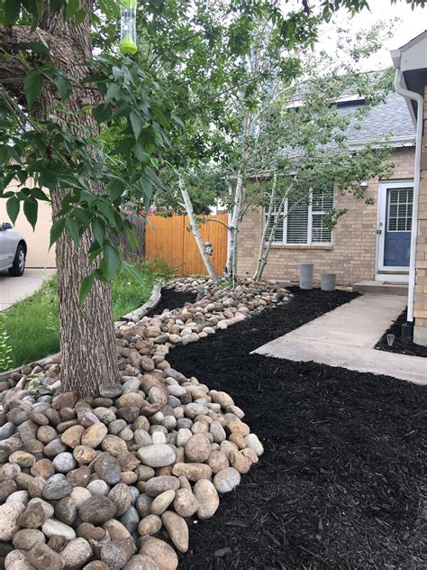 The rocks are very popular among houseowners who wants a more decorative stone for their garden project. Rock river with black mulch | River rock landscaping ...