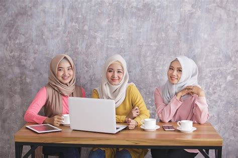 Premium Photo Portrait Of Three Siblings Wearing Hijab Are Busy On Their Own Gadget With