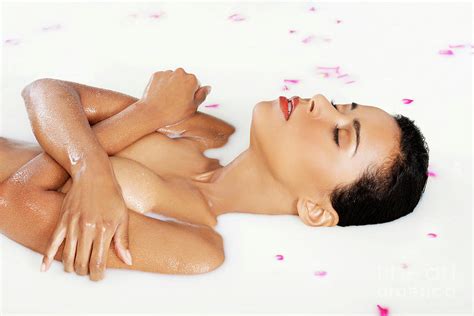 Attractive Naked Woman Lying In A Milk Bath With Rose Petal Up
