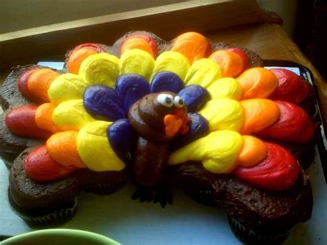A tray full of cupcakes frosted red, yellow, and orange can make a plate full of turkey feathers. Easy Thanksgiving Cupcake Decorating Ideas