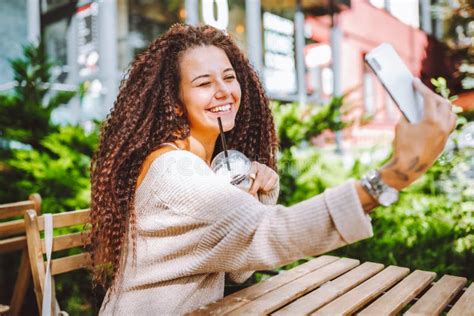 Young Smiling Afro Haired Woman Take Selfie With White Smartphone