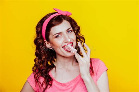 Girl In Pink Dress Pinup Style Eats Cream Licks Fingers Stock Image