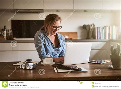 Smiling Female Entrepreneur Working From Home With A Laptop Stock Photo