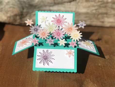 A Close Up Of A Card With Flowers On It And A Piece Of Paper In The Middle