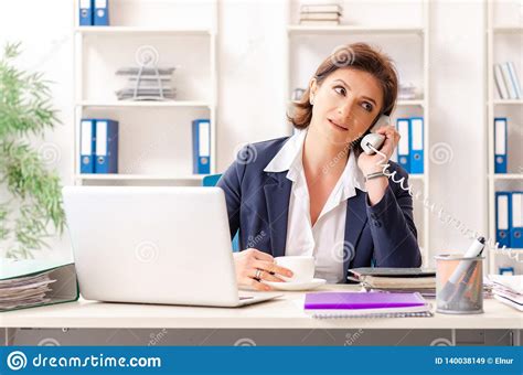the middle aged female employee sitting at the office stock image image of coffee paperwork