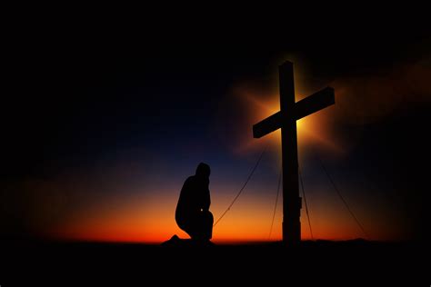 Free Photo Man Kneeling In Front Of Cross Backlit Sunset Sun