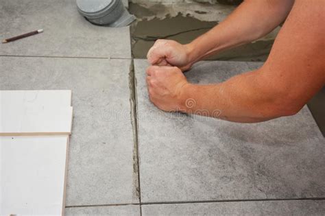 Worker Installing Ceramic Tile On The Floor Bathroom Flooring Stock