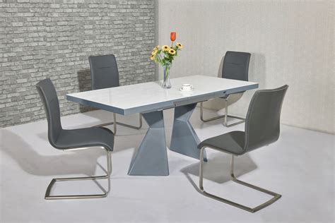 Dark gray dining room table with matching chairs set on a gray and white rug, complemented by blue and white decor. Grey high gloss white glass dining table & 4 chairs - Homegenies