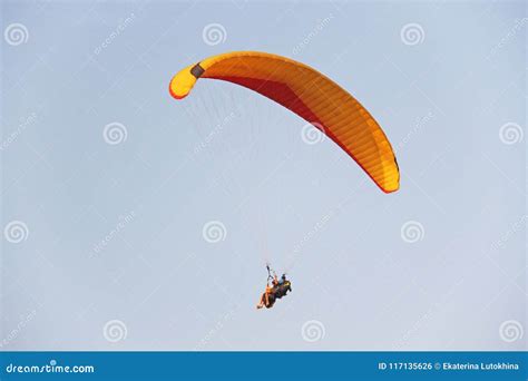 A Paraglider Against The Blue Sky A Bright Paraglider Flies In Stock