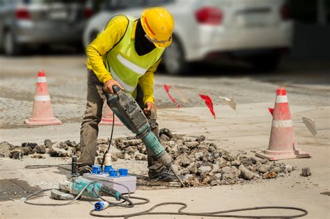 Worker Drilling Concrete Driveway With Jackhammer Man Repairing Road