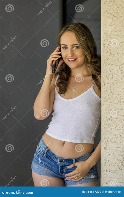 Lovely Brunette Model Posing At Home Receiving News On Her Mobile Device Stock Photo Image Of