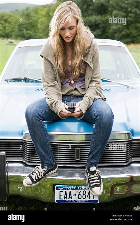Young Woman Sitting On Car Bonnet Fotos Und Bildmaterial In Hoher