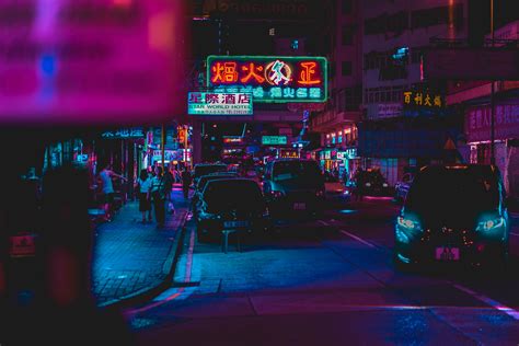 Hong Kong Street At Night With Neon Signs And Lights Reflecting Off Of