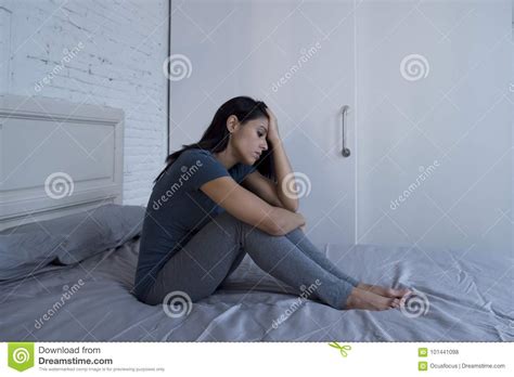 Beautiful Sad And Depressed Latin Woman Sitting On Bed At Home F Stock