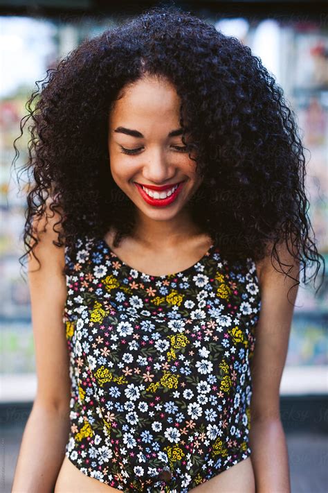 Portrait Of A Young Latin Afro Woman With Red Lips Laughing Outside