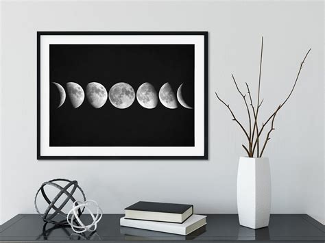 A Black And White Photo Of The Phases Of The Moon In Front Of A Bookshelf