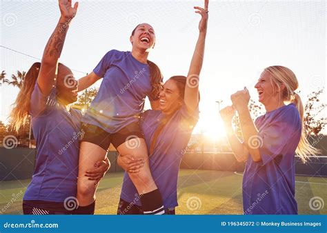 Womens Football Team Celebrating Winning Soccer Match Lifting Player