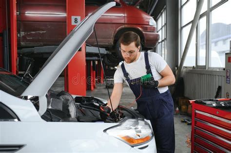 Portrait Shot Of A Handsome Mechanic Working On A Vehicle In A Car