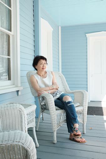 Beautiful Mature Chinese Woman Sitting With Her Door At The Porch Of