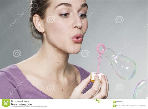 playful 20 s girl blowing soap bubbles for fun and imagination stock image image of beauty