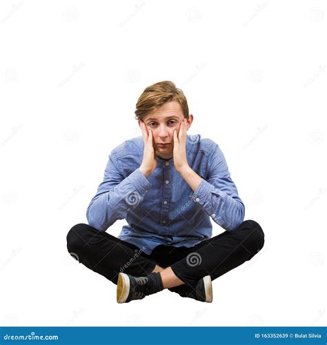 Upset And Stressed Teenage Guy Seated On The Floor With Crossed Legs
