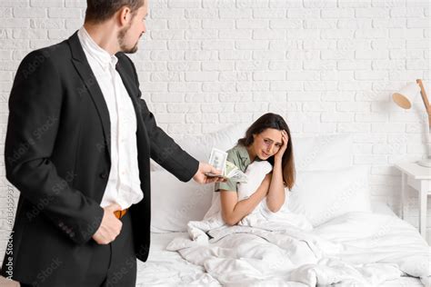 Foto De Young Man Giving Money To His Bruised Wife In Bedroom Domestic