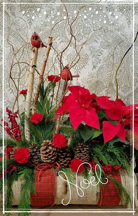 A Christmas Arrangement With Poinsettis Pine Cones And Red Flowers In