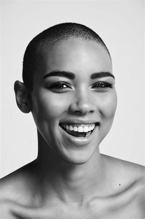 a black and white photo of a woman with short hair smiling at the camera