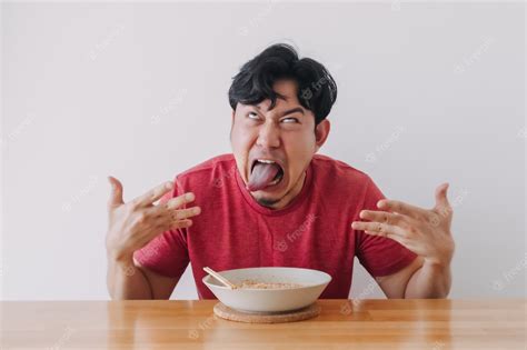 premium photo funny face of man eat very hot and spicy instant noodle
