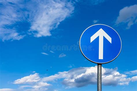 Blue Road Sign With With Arrow Pointing Up At The Blue Sky Stock Image