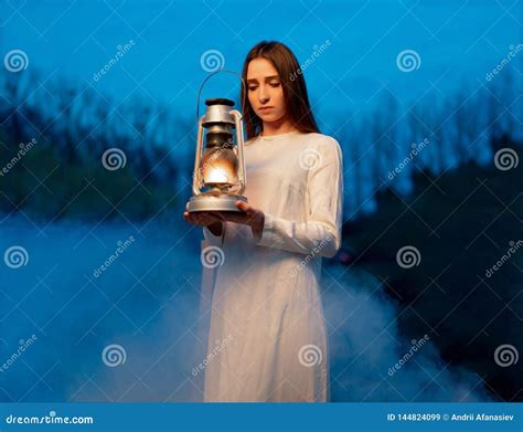 Mysterious Mystical Girl In A Dark Night Forest With A Kerosene Lamp In