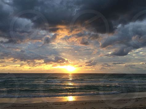 Sunrise Cloudy Sun Ocean Beach By Sandy Root Photo Stock Studionow
