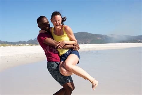 Playful Young Couple Having Fun Outdoors On The Beach Stock Image Image Of Outdoors Holding