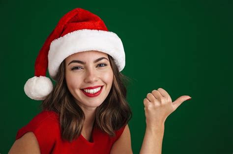 Beautiful Happy Girl In Santa Claus Hat Pointing Finger Aside In 2023 Happy Girls Santa Claus