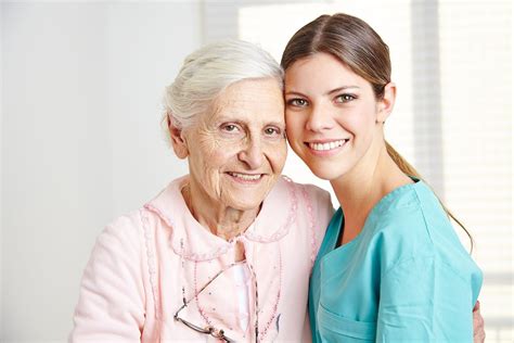 Smiling Caregiver Embracing Happy Senior Woman In Nursing Home Lpn Programs Near You