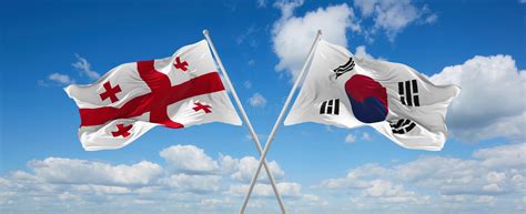 Two Crossed Flags South Korea And Georgia Waving In Wind At Cloudy Sky Concept Of Relationship