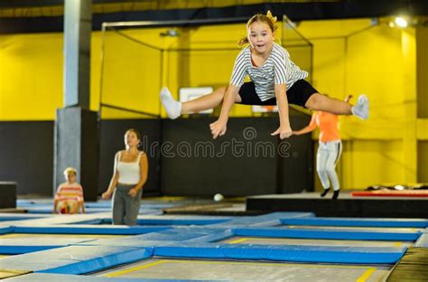 Cheerful Girl Bouncing Spreading Her Legs On Trampolines During Free